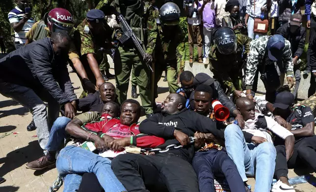 Police arrest protesters who have chained themselves during protests against abductions in Nairobi, Kenya, Monday, Dec. 30, 2024. AP Photo/Andrew Kasuku)