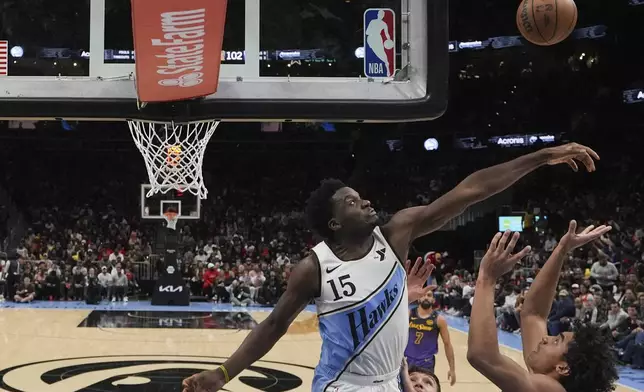 Atlanta Hawks center Clint Capela (15) stops Los Angeles Lakers guard Max Christie (12) from scoring in the second half of an NBA basketball game, Friday, Dec. 6, 2024, in Atlanta. (AP Photo/Brynn Anderson)