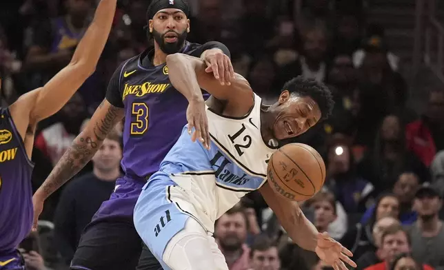 Los Angeles Lakers forward Anthony Davis (3) fouls Atlanta Hawks forward De'Andre Hunter (12) in the second half of an NBA basketball game, Friday, Dec. 6, 2024, in Atlanta. (AP Photo/Brynn Anderson)