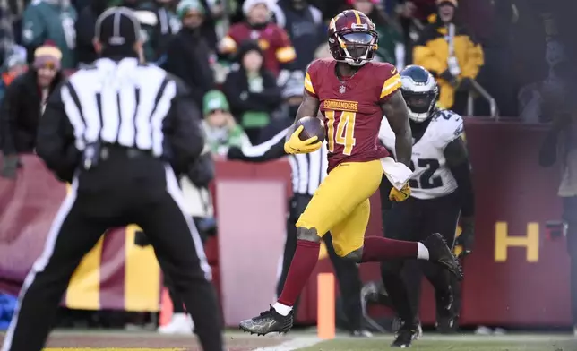 Washington Commanders wide receiver Olamide Zaccheaus (14) scores a touchdown against the Philadelphia Eagles during the second half of an NFL football game, Sunday, Dec. 22, 2024, in Landover, Md. (AP Photo/Nick Wass)