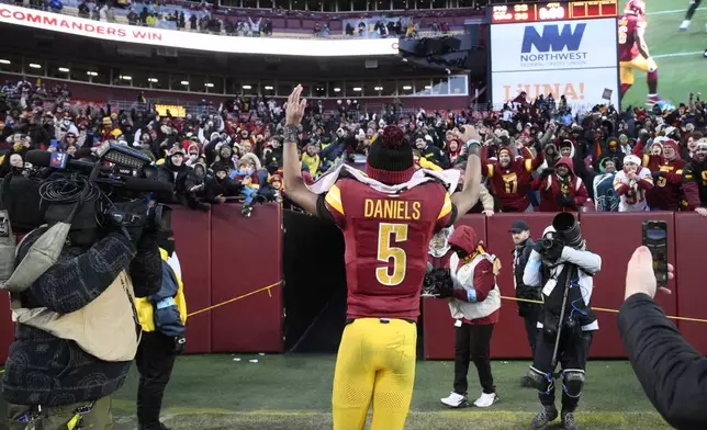 Washington Commanders quarterback Jayden Daniels (5) acknowledges fans as he heads off the field at the end of an NFL football game against the Philadelphia Eagles, Sunday, Dec. 22, 2024, in Landover, Md. (AP Photo/Nick Wass)