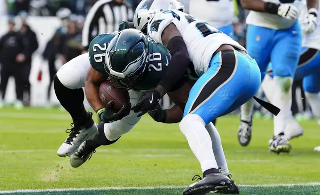 Philadelphia Eagles running back Saquon Barkley (26) dives into the end zone for a 2-point conversion against Carolina Panthers safety Xavier Woods (25) during the second half of an NFL football game Sunday, Dec. 8, 2024, in Philadelphia. (AP Photo/Derik Hamilton)