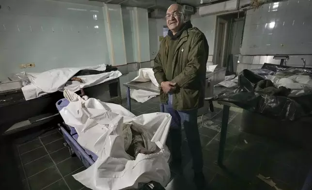 EDS NOTE: GRAPHIC CONTENT - Imad Habbal stands next to the body of his brother, Diaa Habbal, at the morgue of Al-Mojtahed Hospital in Damascus, Syria, on Wednesday, Dec. 11, 2024. Diaa was arrested by the Syrian military police six months ago after returning to Damascus from Saudi Arabia, where he had been living since 2003. He came back in mid-2024 to visit his family and was arrested on charges of evading military service. (AP Photo/Hussein Malla)