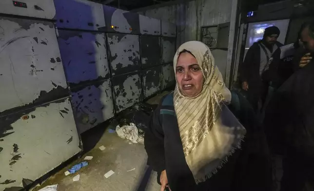 A woman leaves the morgue at Al-Mojtahed hospital in Damascus, Syria, on Wednesday, Dec. 11, 2024. Syrians are flocking to morgues, hoping to identify their slain loved ones who are missing or may have been imprisoned under the rule of President Bashar Assad, whose government collapsed over the weekend. (AP Photo/Hussein Malla)