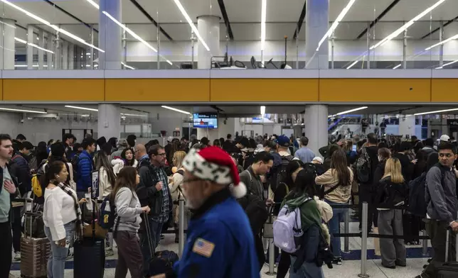 Travelers wait in line for security checks at the Los Angeles International Airport in Los Angeles, Tuesday, Dec. 24, 2024. (AP Photo/Jae C. Hong)