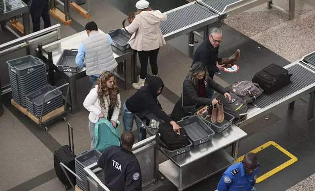 Travellers queue up to pass through the south security checkpoint in the main terminal of Denver International Airport Tuesday, Dec. 24, 2024, in Denver. (AP Photo/David Zalubowski)