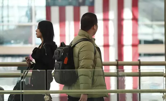 Travellers pass the main terminal of Denver International Airport Tuesday, Dec. 24, 2024, in Denver. (AP Photo/David Zalubowski)