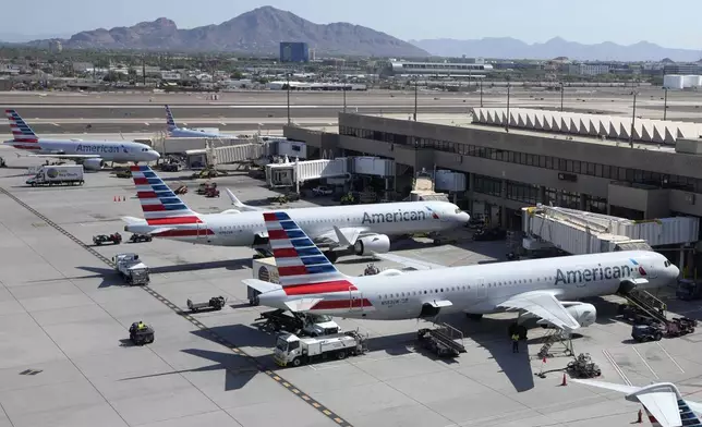 FILE - American Airlines planes wait at gates at Phoenix Sky Harbor International Airport Friday, July 19, 2024, in Phoenix. (AP Photo/Ross D. Franklin, File)