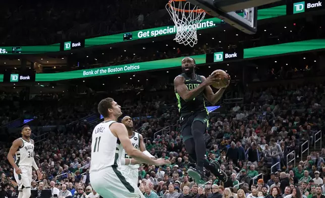 Boston Celtics guard Jaylen Brown (7) drives to the basket as Milwaukee Bucks center Brook Lopez (11) looks on during the first half of an NBA basketball game, Friday, Dec. 6, 2024, in Boston. (AP Photo/Mary Schwalm)