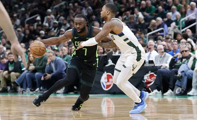 Boston Celtics guard Jaylen Brown (7) drives against Milwaukee Bucks guard Damian Lillard (0) during the first half of an NBA basketball game, Friday, Dec. 6, 2024, in Boston. (AP Photo/Mary Schwalm)