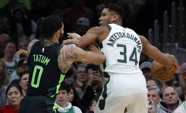 Milwaukee Bucks forward Giannis Antetokounmpo (34) drives against Boston Celtics forward Jayson Tatum (0) during the first half of an NBA basketball game, Friday, Dec. 6, 2024, in Boston. (AP Photo/Mary Schwalm)