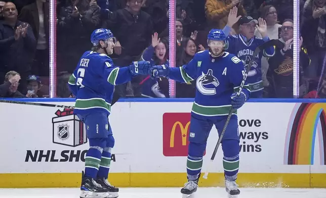Vancouver Canucks' Brock Boeser (6) and J.T. Miller (9) celebrate Boeser's goal against the Florida Panthers during the second period of an NHL hockey game, Thursday, Dec. 12, 2024 in Vancouver, British Columbia. (Darryl Dyck/The Canadian Press via AP)