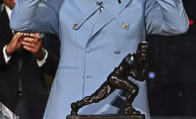 Colorado’s Travis Hunter gestures after winning the Heisman Trophy as the outstanding player in college football, Saturday, Dec. 14, 2024, in New York. (Todd Van Emst/Heisman Trust via AP, Pool)