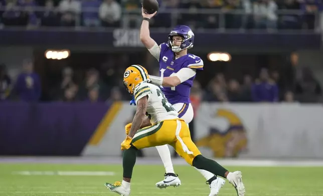 Minnesota Vikings' Sam Darnold throws while being pressured by Green Bay Packers' Keisean Nixon during the first half of an NFL football game Sunday, Dec. 29, 2024, in Minneapolis. (AP Photo/Abbie Parr)