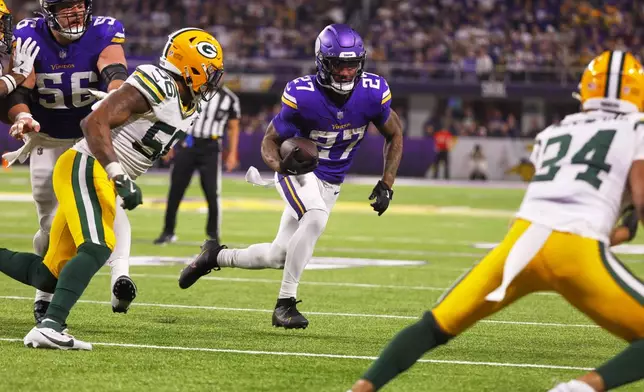 Minnesota Vikings' Cam Akers runs for a touchdown after a catch during the second half of an NFL football game against the Green Bay Packers Sunday, Dec. 29, 2024, in Minneapolis. (AP Photo/Bruce Kluckhohn)