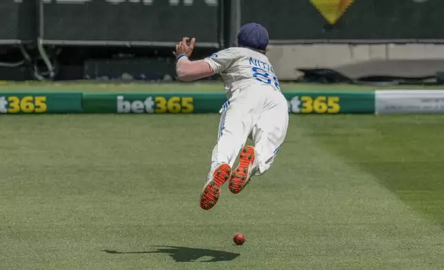 India's Nitish Kumar Reddy dives in an attempt to take a catch of Australia's captain Pat Cummins during play on the day four of the fourth cricket test between Australia and India at the Melbourne Cricket Ground, Melbourne, Australia, Sunday, Dec. 29, 2024. (AP Photo/Asanka Brendon Ratnayake)