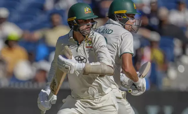 Australia's Nathan Lyon, left, and Scott Boland run between the wickets to score during play on the day four of the fourth cricket test between Australia and India at the Melbourne Cricket Ground, Melbourne, Australia, Sunday, Dec. 29, 2024. (AP Photo/Asanka Brendon Ratnayake)