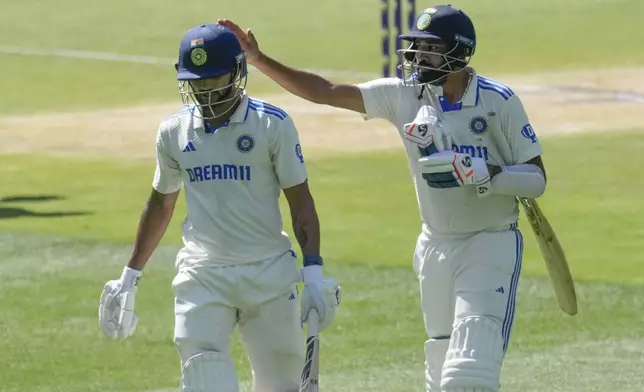 India's Mohammed Siraj,right, pats to applaud batting partner Nitish Kumar Reddy as they leave the field at the end of their innings during play on the day four of the fourth cricket test between Australia and India at the Melbourne Cricket Ground, Melbourne, Australia, Sunday, Dec. 29, 2024. (AP Photo/Asanka Brendon Ratnayake)