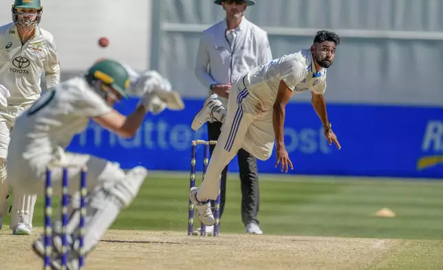 India's Mohammed Siraj, right, bowls a bouncer to Australia's captain Pat Cummins during play on the day four of the fourth cricket test between Australia and India at the Melbourne Cricket Ground, Melbourne, Australia, Sunday, Dec. 29, 2024. (AP Photo/Asanka Brendon Ratnayake)