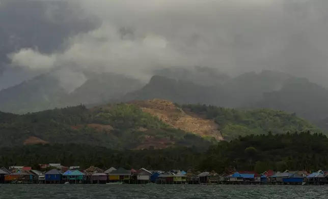 A nickel mine is visible on top of a hill above a village on Kabaena Island in South Sulawesi, Indonesia, Thursday, Nov. 14, 2024. (AP Photo/Yusuf Wahil)