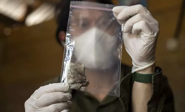 Dhany Alfalah, a researcher with Satya Bumi, a nonprofit environmental organization, shows dust samples collected from a house on Kabaena Island in South Sulawesi, Indonesia, Friday, Nov. 15, 2024. (AP Photo/Yusuf Wahil)