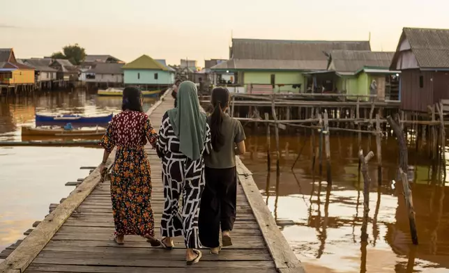 People walk through Baliara village on Kabaena Island in South Sulawesi, Indonesia, Friday, Nov. 15, 2024. (AP Photo/Yusuf Wahil)