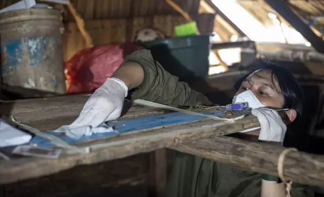 Dhany Alfalah, a researcher for Satya Bumi, a nonprofit environmental organization, collects dust samples from a house on Kabaena Island in South Sulawesi, Indonesia, Friday, Nov. 15, 2024. (AP Photo/Yusuf Wahil)