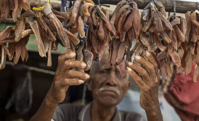 Ilyas, 70, who has been complaining of itchy skin rashes, checks on his dried fish at his house on Kabaena Island near nickel mining activities in South Sulawesi, Indonesia, Friday, Nov. 15, 2024. (AP Photo/Yusuf Wahil)