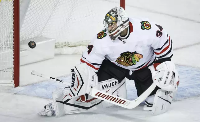 Chicago Blackhawks goalie Petr Mrazek deflects a shot during the first period of an NHL hockey game in Calgary, Alberta, Saturday, Dec. 21, 2024. (Jeff McIntosh/The Canadian Press via AP)Hockey