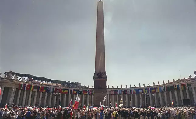 FILE - A view of youths lining up in the middle of St. Peter's Square, to cross the Holy Door inside the Basilica at The Vatican, Wednesday August 16, 2000. (AP Photo/Enric Marti, File)