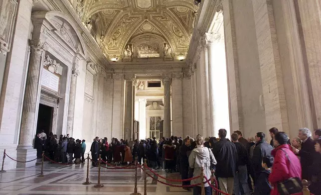 FILE - Pilgrims line to walk through St. Peter's Basilica's Holy Door at the Vatican, Tuesday, December 28, 1999. (AP Photo/Massimo Sambucetti, File)