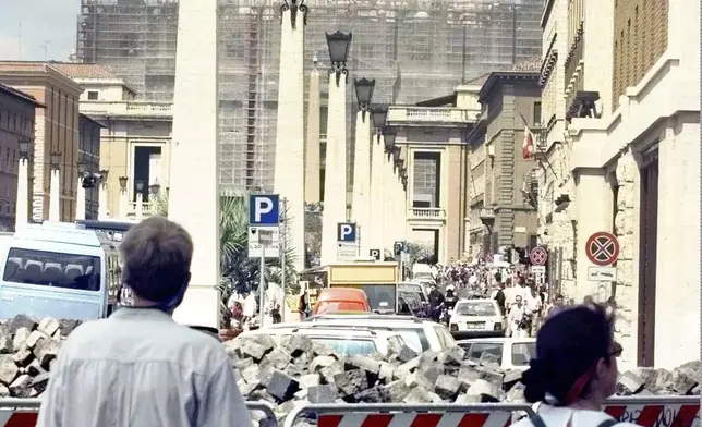 FILE - Tourists approaching the Vatican's St. Peter's Basilica Saturday, July 11, 1998, walk through street works. (AP Photo/Massimo Sambucetti, File)