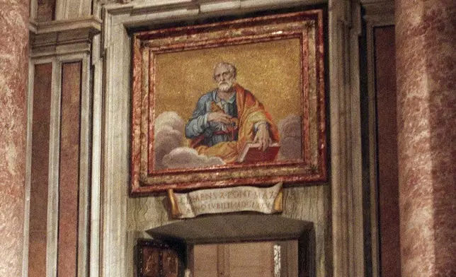 FILE - Pope John Paul II walks through the bronze Holy Door of St. Peter's Basilica at the Vatican, late Friday night, Dec. 24, 1999. (AP Photo/Andrew Medichini, File)