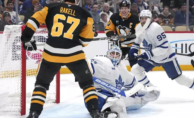 Pittsburgh Penguins' Rickard Rakell (67) can't get his stick on a rebound off Toronto Maple Leafs goaltender Joseph Woll (60) during the second period of an NHL hockey game Saturday, Dec. 7, 2024, in Pittsburgh. (AP Photo/Gene J. Puskar)