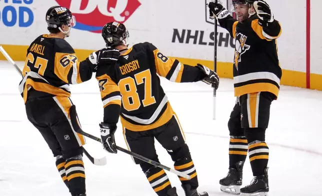 Pittsburgh Penguins' Bryan Rust, right, celebrates with Sidney Crosby (87) and Rickard Rakell (67) after scoring during the first period of an NHL hockey game against the Toronto Maple Leafs, Saturday, Dec. 7, 2024, in Pittsburgh. (AP Photo/Gene J. Puskar)