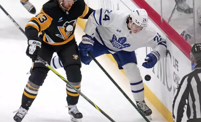 Pittsburgh Penguins' Kevin Hayes (13) checks Toronto Maple Leafs' Connor Dewar (24) off the puck during the first period of an NHL hockey game Saturday, Dec. 7, 2024, in Pittsburgh. (AP Photo/Gene J. Puskar)