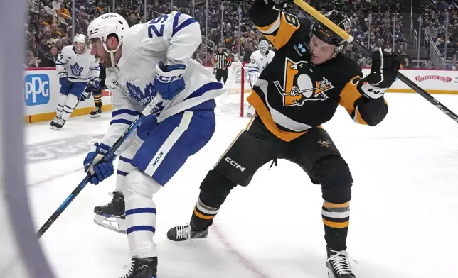 Pittsburgh Penguins' Owen Pickering, right, battles Toronto Maple Leafs' Conor Timmins (25) for the puck during the second period of an NHL hockey game Saturday, Dec. 7, 2024, in Pittsburgh. (AP Photo/Gene J. Puskar)