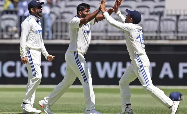 India's captain Jasprit Bumrah, center, celebrates with teammate Dhruv Jurel the wicket of Australia's Travis Head on the fourth day of the first cricket test between Australia and India in Perth, Australia, Monday, Nov. 25, 2024. (AP Photo/Trevor Collens)