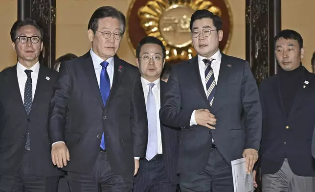 South Korea's main opposition Democratic Party leader Lee Jae-myung, front left, and its floor leader Park Chan-dae, front right, leave a room at the National Assembly in Seoul after South Korea’s parliament voted to impeach President Yoon Suk Yeol Saturday, Dec. 14, 2024. (Kyodo News via AP)