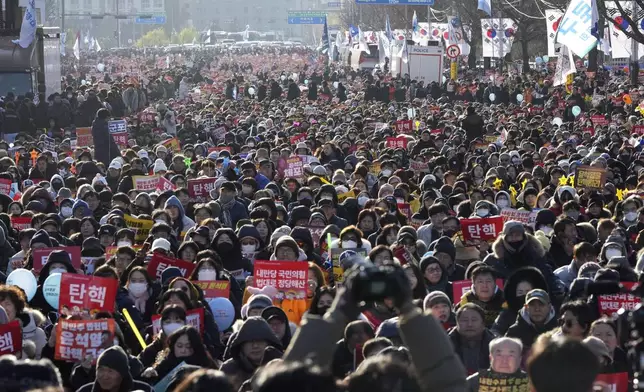 People attend at a rally to demand South Korean President Yoon Suk Yeol's impeachment outside the National Assembly in Seoul, South Korea, Saturday, Dec. 14, 2024. The letters read "Impeachment." (AP Photo/Lee Jin-man)