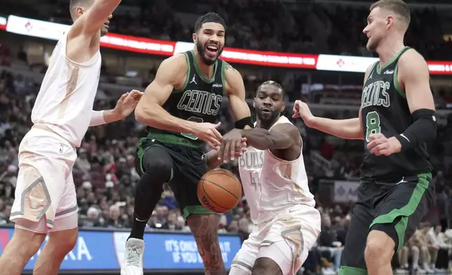 Chicago Bulls' Patrick Williams (44) strips the ball from Boston Celtics' Jayson Tatum as Nikola Vucevic, left, and Kristaps Porzingis watch during the first half of an NBA basketball game Saturday, Dec. 21, 2024, in Chicago. (AP Photo/Charles Rex Arbogast)