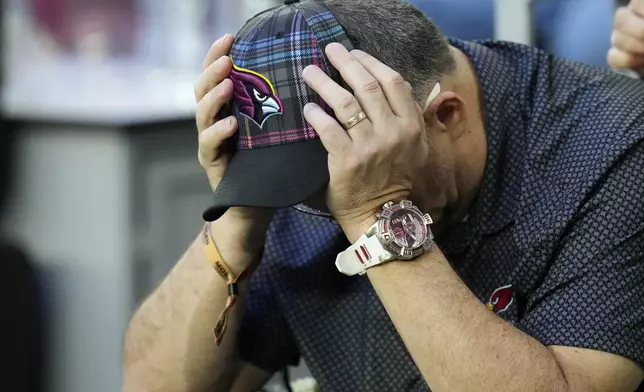An Arizona Cardinals fan looks down during the second half of an NFL football game against the Seattle Seahawks Sunday, Dec. 8, 2024, in Glendale, Ariz. The Seahawks won 30-18. (AP Photo/Ross D. Franklin)