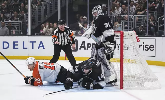 Philadelphia Flyers right wing Garnet Hathaway (19) and Los Angeles Kings right wing Alex Laferriere (14) collide near the Kings' goal during the first period of an NHL hockey game Sunday, Dec. 29, 2024, in Los Angeles. (AP Photo/William Liang)