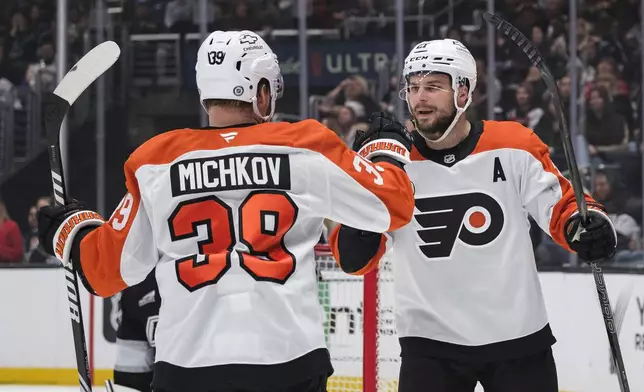 Philadelphia Flyers center Scott Laughton, right, celebrates with right wing Matvei Michkov (39) after scoring a goal during the first period of an NHL hockey game against the Los Angeles Kings, Sunday, Dec. 29, 2024, in Los Angeles. (AP Photo/William Liang)