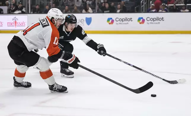 Philadelphia Flyers right wing Travis Konecny (11) and Los Angeles Kings defenseman Jordan Spence (21) vie for the puck during the first period of an NHL hockey game Sunday, Dec. 29, 2024, in Los Angeles. (AP Photo/William Liang)