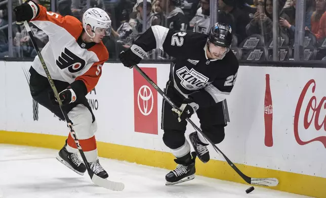 Los Angeles Kings left wing Kevin Fiala (22) looks to pass the puck while under pressure from Philadelphia Flyers defenseman Egor Zamula (5) during the second period of an NHL hockey game Sunday, Dec. 29, 2024, in Los Angeles. (AP Photo/William Liang)