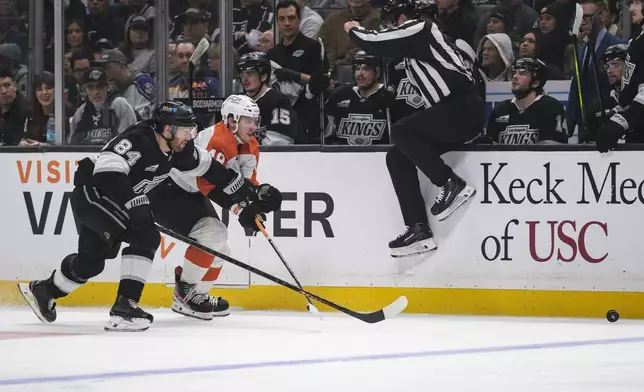 Los Angeles Kings defenseman Vladislav Gavrikov (84) and Philadelphia Flyers center Morgan Frost (48) vie for the puck during the third period of an NHL hockey game Sunday, Dec. 29, 2024, in Los Angeles. (AP Photo/William Liang)