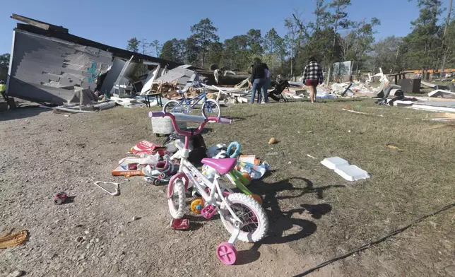 CORRECTS LOCATION Residents near New Caney, Texas, survey damage Monday, Dec. 30, 2024, following a strong weekend storm system that spawned hail, rain, high winds and tornadoes across the southern U.S. (AP Photo/Lekan Oyekanmi)