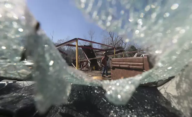 CORRECTS LOCATION A man walks though debris near New Caney, Texas, Monday, Dec. 30, 2024, following a strong weekend storm system that spawned hail, rain, high winds and tornadoes across the southern U.S. (AP Photo/Lekan Oyekanmi)