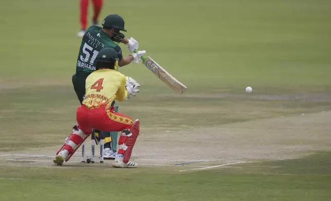 Pakistan's Sahibzada Farhan at the wicket in front of Zimbabwe's Tadiwanashe Marumani during the third T20 cricket match between Zimbabwe and Pakistan at Queens Sports Club in Bulawayo, Zimbabwe, Thursday, Dec. 5, 2024. (AP Photo/Wonder Mashura)